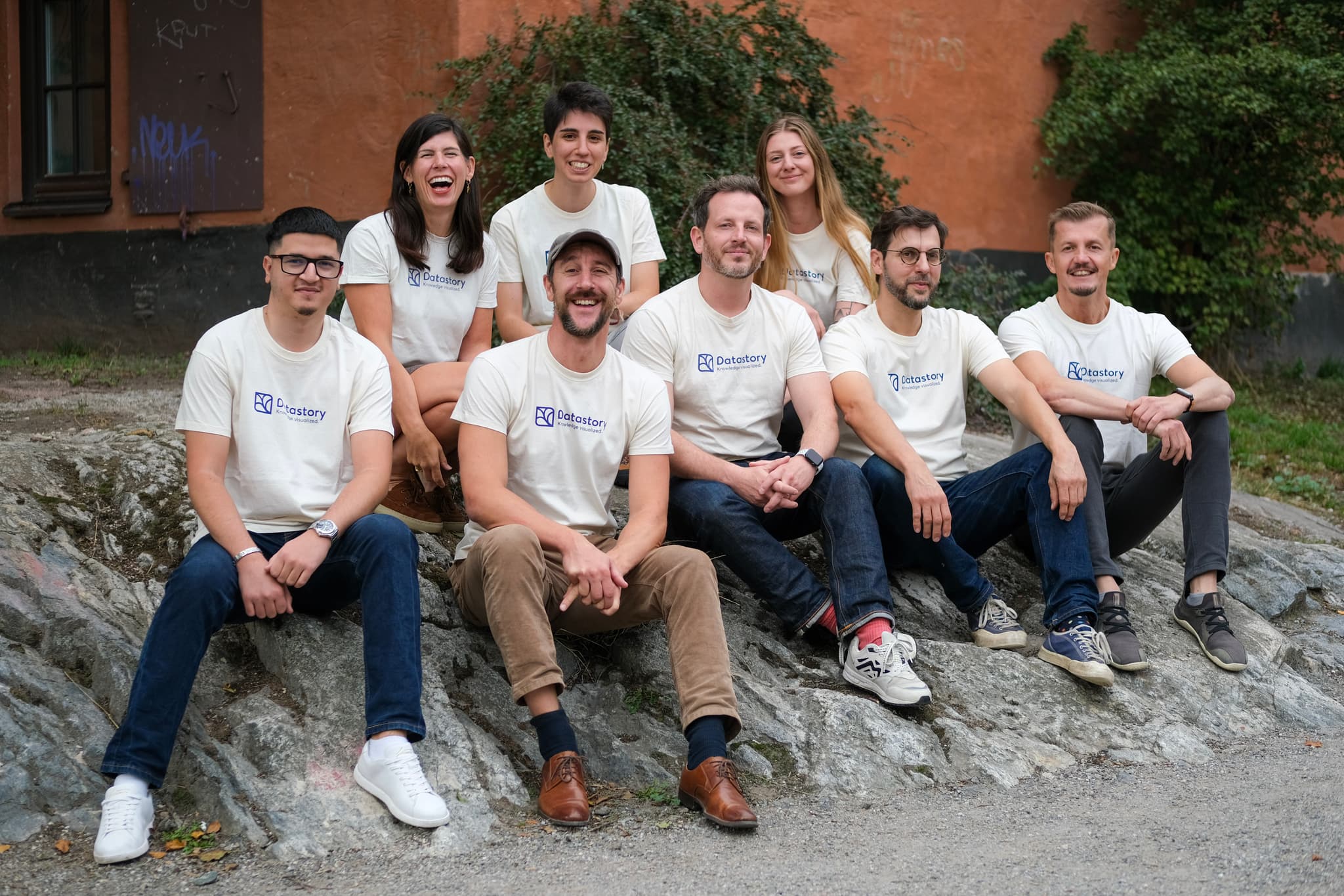 Team in matching shirts sitting on rocks